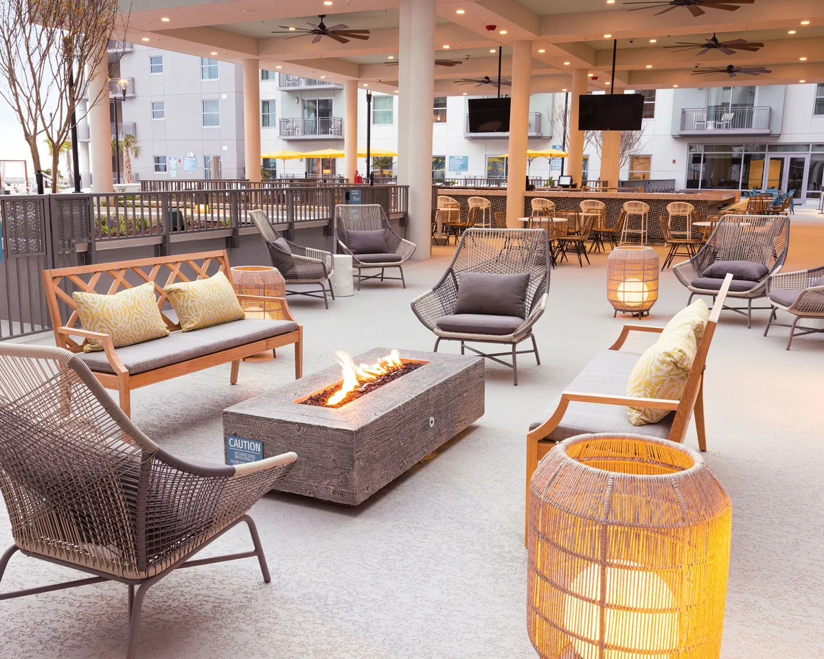 An inviting fire pit area surrounded by comfortable seating and accented with decorative lanterns. The setup suggests a perfect spot for socializing, celebrating special occasions, or simply relaxing with a group in a cozy, outdoor environment.